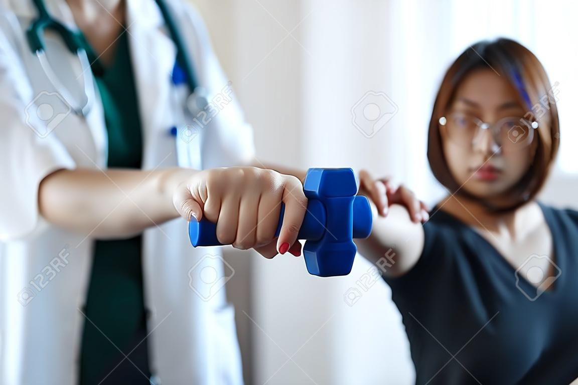 Woman doing the Rehabilitation therapy pain in clinic. Doctor or Physiotherapist. Doctor or Physiotherapist examining treating injured arm and shoulder.