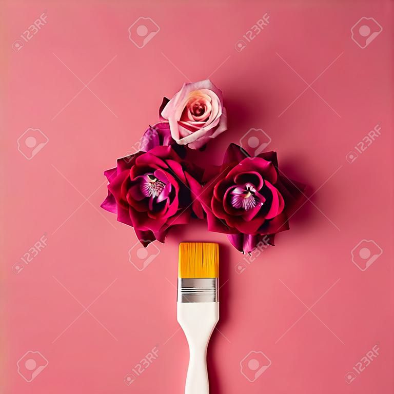 purpurrote Blumen und Pinsel auf rosa Hintergrund . Flach legen