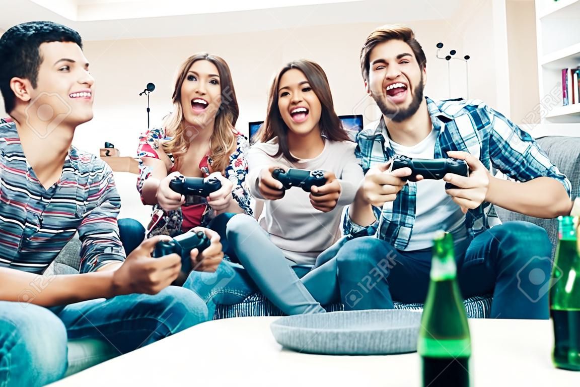 Group of friends having fun and  play video games together.