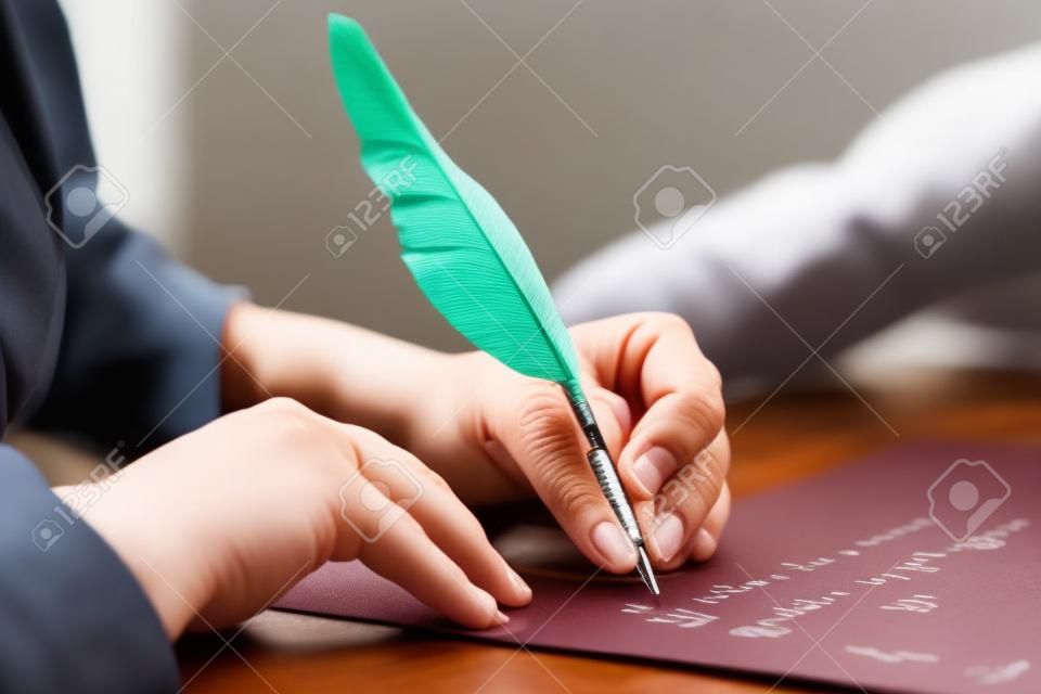 manos al escribir una carta con una pluma