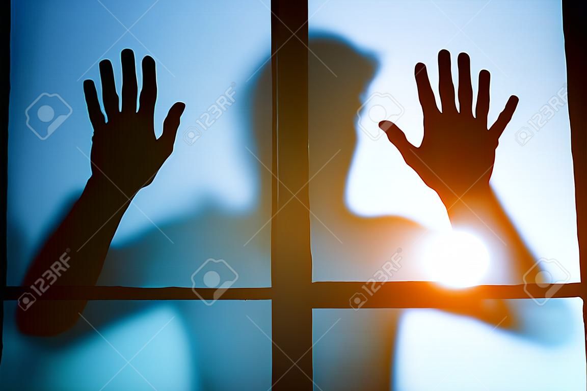 silueta hombre asustado parado detrás de la puerta de cristal, fondo de terror