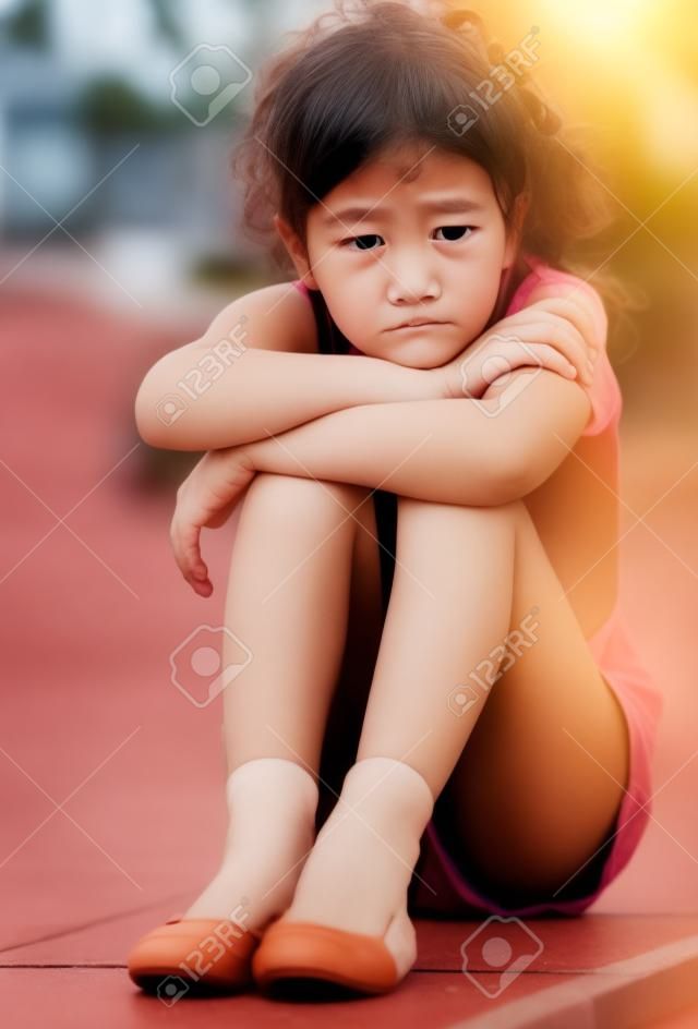Eenzaam meisje in de basisschool leeftijd huilen en het gevoel verward buiten