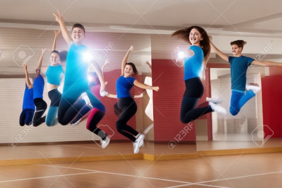 Group of teenagers jumping during dance workout