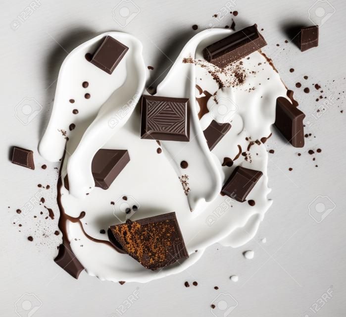 Chocolate bars in milk splash, isolated on white background 