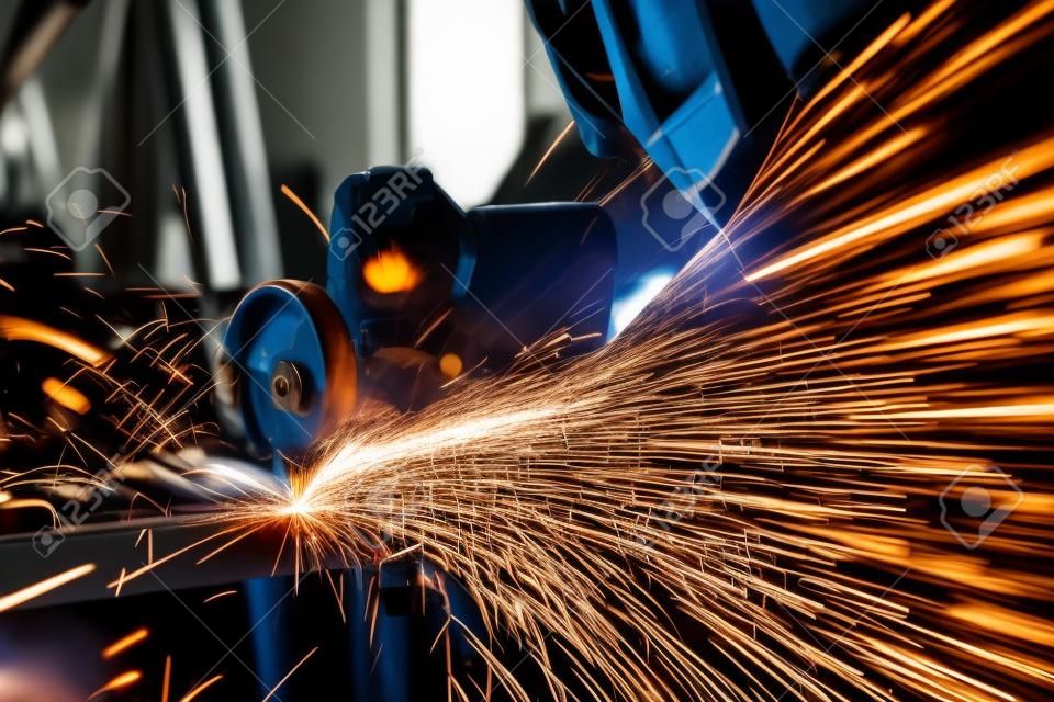 労働者は、グラインダーで金属を切断のクローズ アップ。鉄を研削しながら火花します。低焦点深度