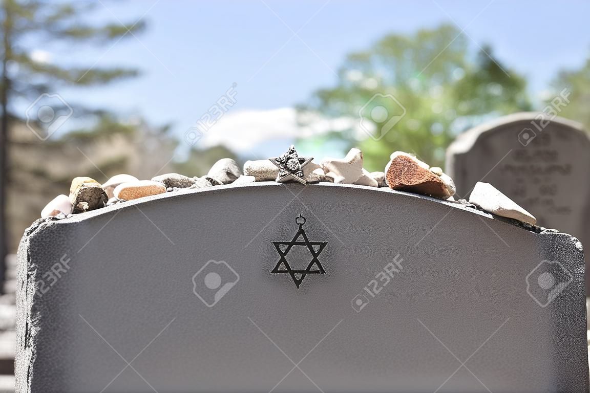 Grafsteen op een Joodse begraafplaats met Davidster en geheugenstenen. Selectieve focus op de voorgrond. Kopieer ruimte.
