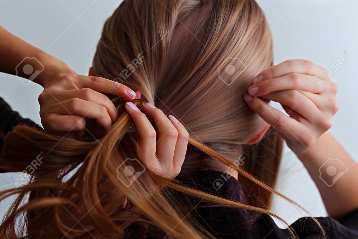 Natural blonde woman doing a ponytail, holding her hair, stop motion, back view,