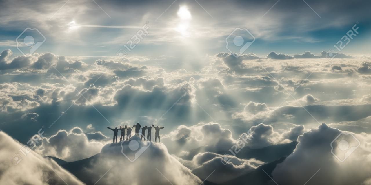 對世界的頂端在一起。一群人站在一座小山上俯瞰美麗的雲景。
