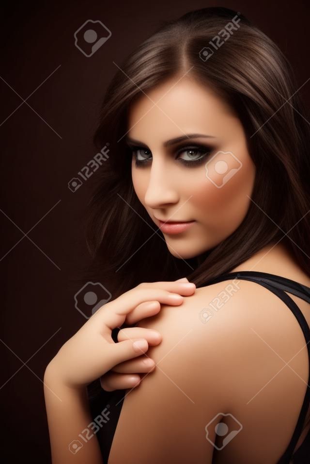 Schönes Brunette-Mädchen über schwarzem Hintergrund