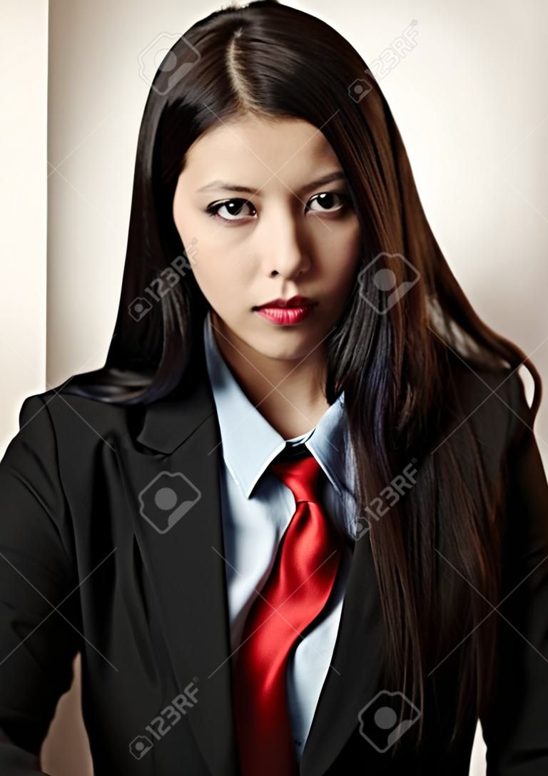young woman dressed up in a man suit and tie looking at camera