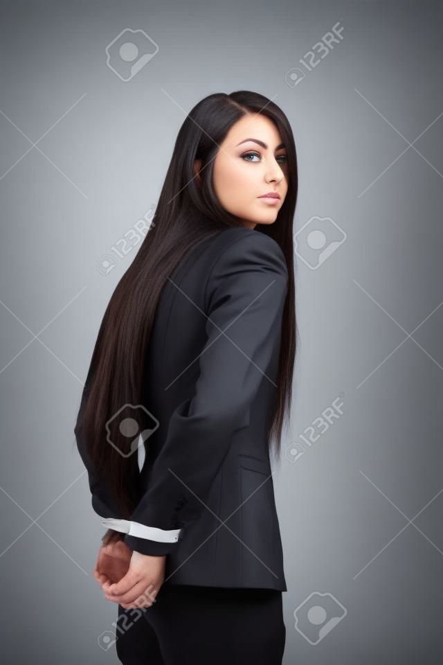 femme vêtue d'un costume d'affaires avec sa main attachée derrière le dos