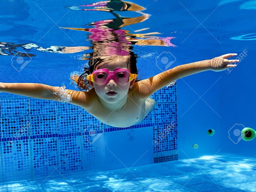 Kid swimming underwater in the pool
