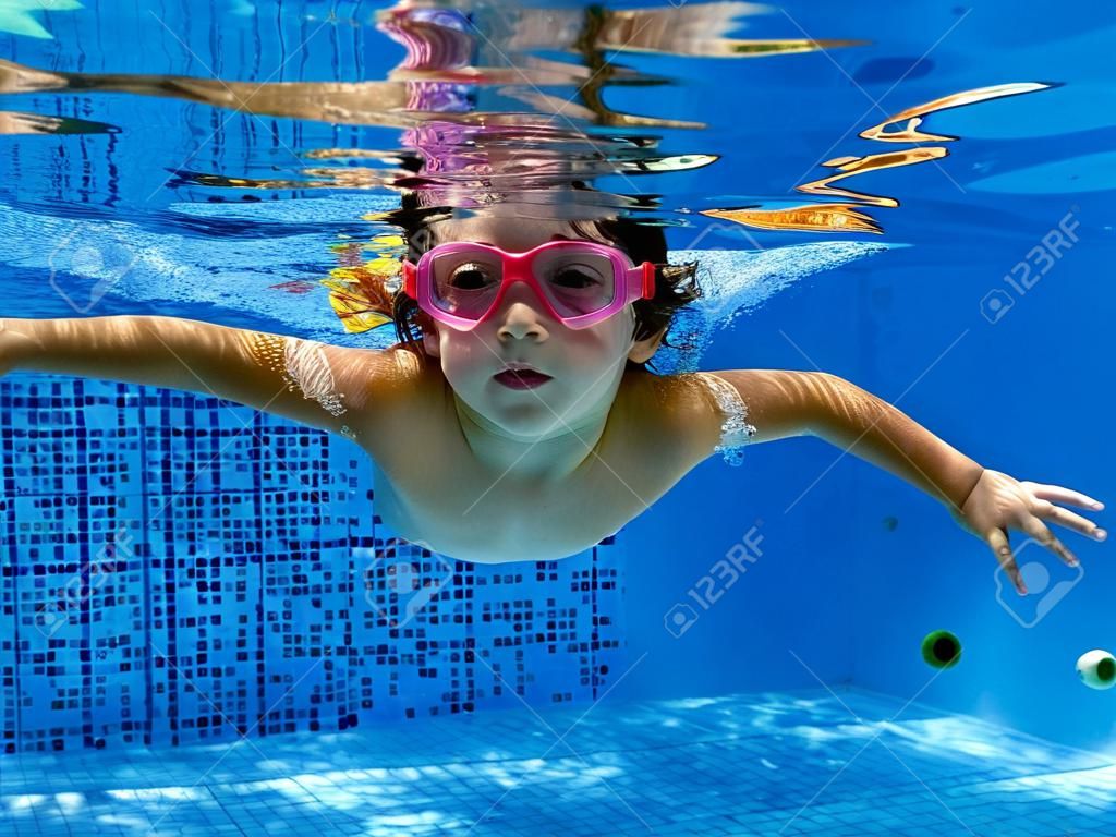 Kid swimming underwater in the pool