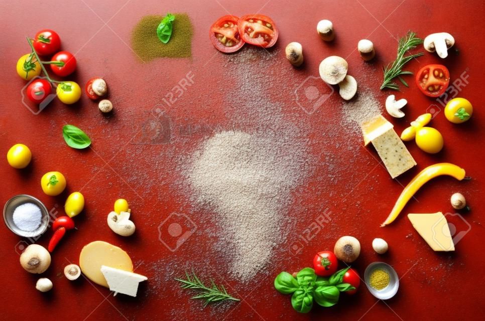 Food ingredients and spices for cooking pizza. Mushrooms, tomatoes, cheese, onion, oil, pepper, salt, basil, grater, olive on rustic background. Copyspace. Top view