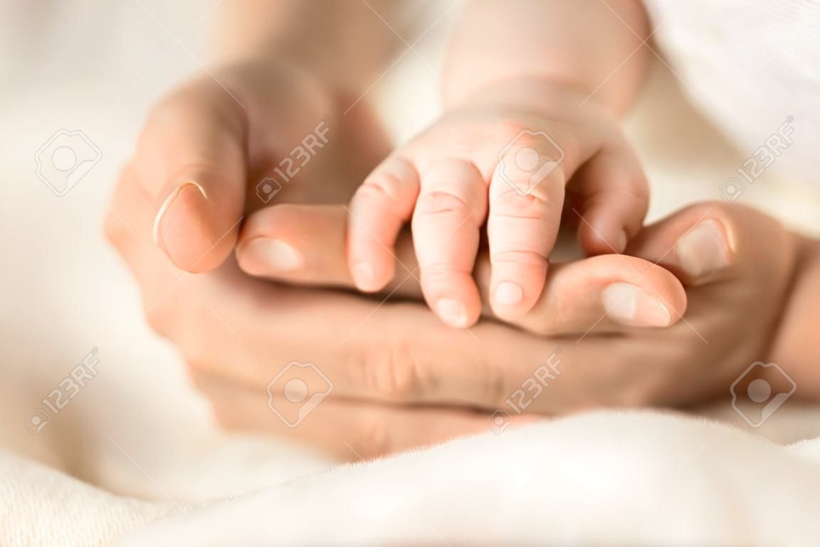 그녀의 갓난 아기 손을 잡고 여성 손입니다. 그녀의 아이와 엄마입니다. 출산, 가족, 출생 개념. 텍스트를 위한 공간 복사