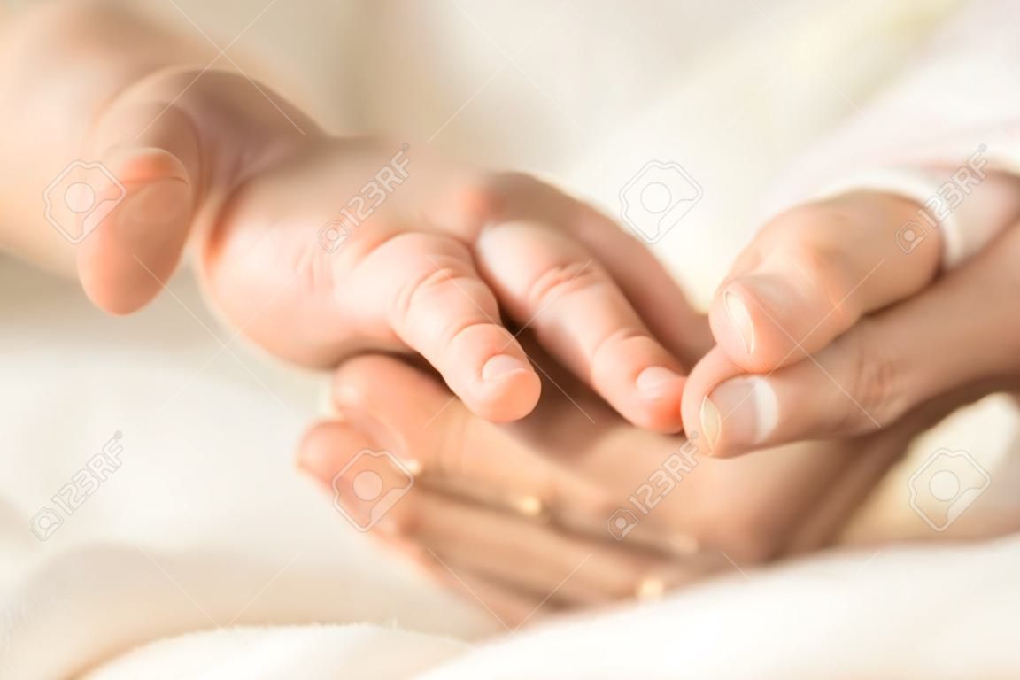 그녀의 갓난 아기 손을 잡고 여성 손입니다. 그녀의 아이와 엄마입니다. 출산, 가족, 출생 개념. 텍스트를 위한 공간 복사