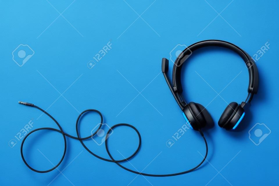 Style black headphones on blue background. Top view. Copy space. Music and sound concept. Urban summer time.