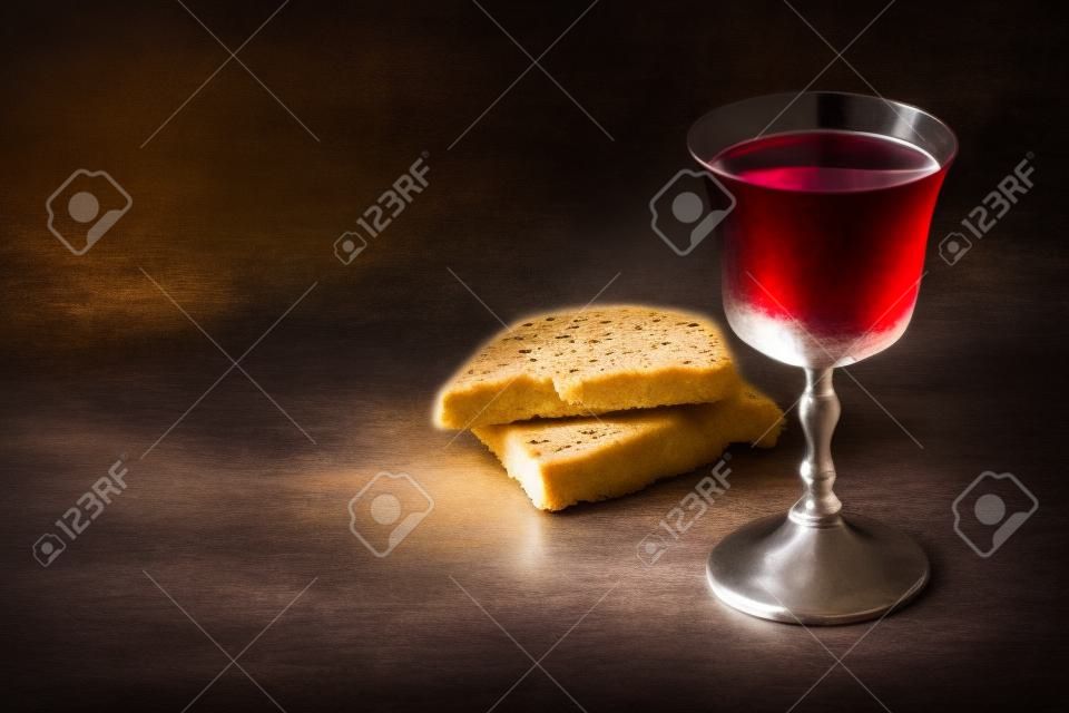 Unleavened bread, chalice of wine, silver kiddush wine cup on canva background. Communion still life. Christian communion concept for reminder of Jesus sacrifice. Easter passover.