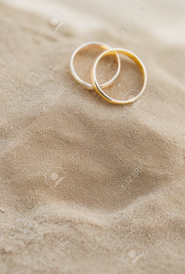 Anelli di cerimonia nuziale nella sabbia in spiaggia