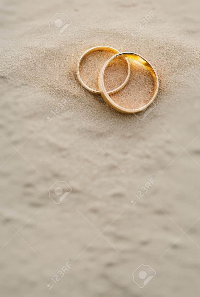 Anillos de boda en la arena de la playa