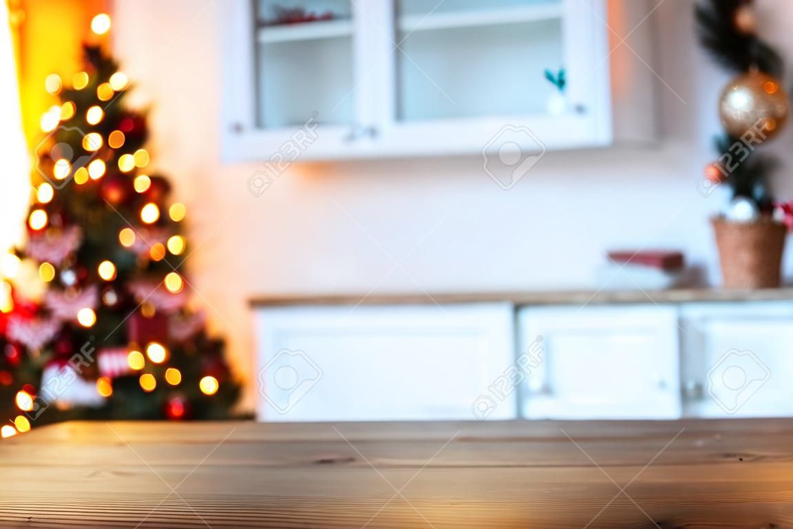 Sfondo vacanza di Natale con tavolo rustico vuoto e il bokeh del soggiorno con l'albero di Natale sul secondo piano