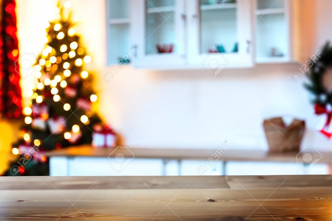 Sfondo vacanza di Natale con tavolo rustico vuoto e il bokeh del soggiorno con l'albero di Natale sul secondo piano