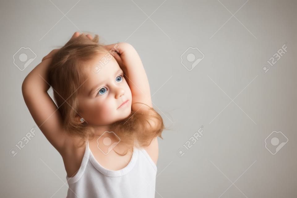 Retrato de niña feliz de 4 años aislado sobre fondo gris