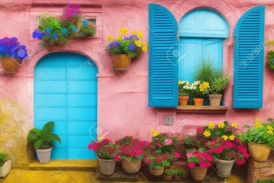 色とりどりの鉢植えの花を持つイタリアの家の前部