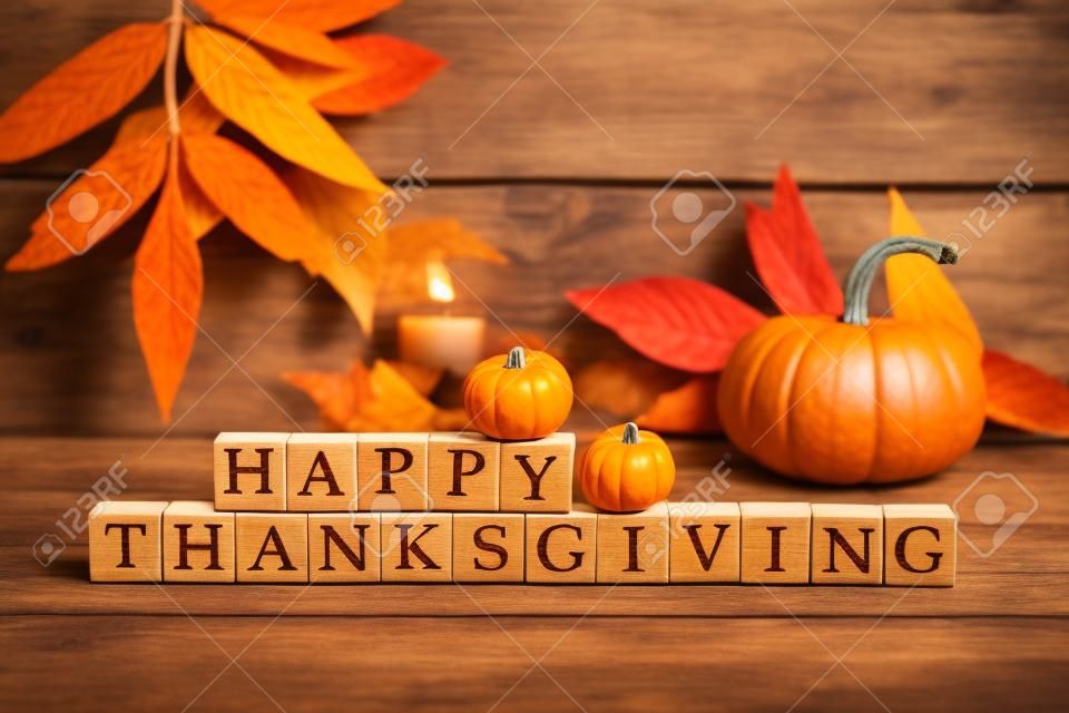 Happy Thanksgiving Holzblöcke vor einem rustikalen Holz Hintergrund mit Kürbissen und Herbstlaub