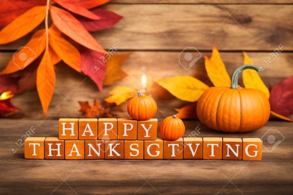 Happy Thanksgiving Holzblöcke vor einem rustikalen Holz Hintergrund mit Kürbissen und Herbstlaub