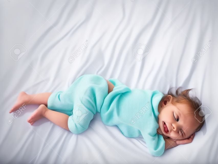 Kindpink auf einer Matratze, Füße des kleinen Mädchens und Pipi im Bettlaken, Entwicklungskonzept des Kindes, ausgewählter Fokus.