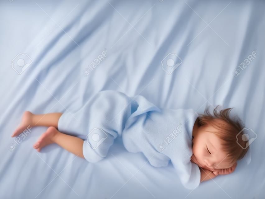 Kindpink auf einer Matratze, Füße des kleinen Mädchens und Pipi im Bettlaken, Entwicklungskonzept des Kindes, ausgewählter Fokus.