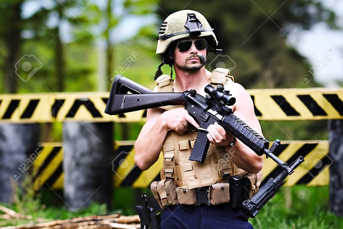 Powerful mercenary with submachine gun guarding a roadblock