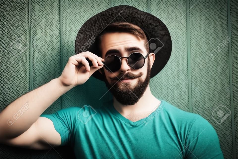 Homem de hipster barbudo em chapéu e óculos de sol