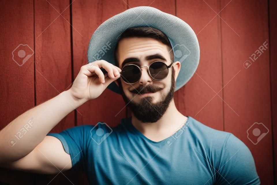 Homem de hipster barbudo em chapéu e óculos de sol