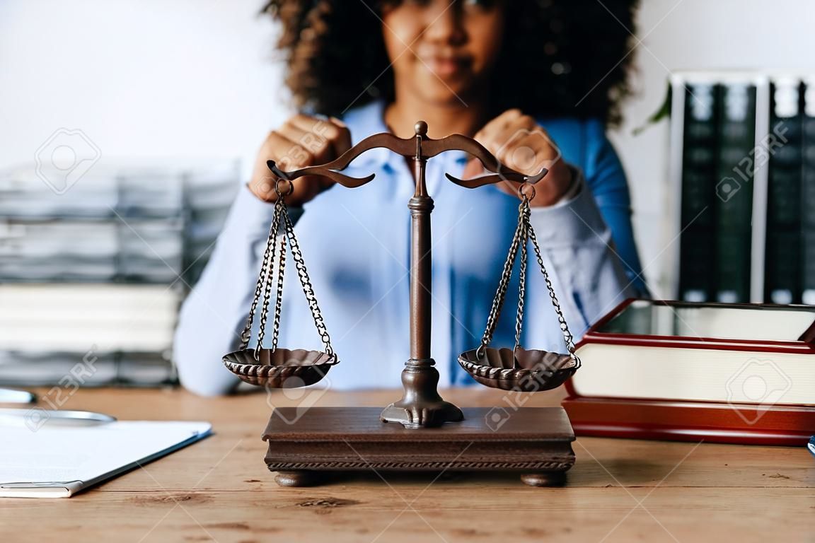 Young african american lawyer studying case for client and holding gavel in a symbolic gesture against her opponent in court Legal and lawyer concepts