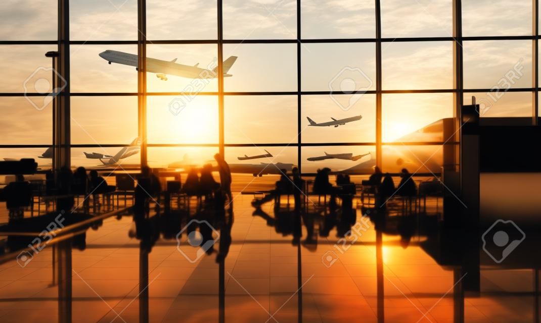 乗客と日没時の空港ターミナル。