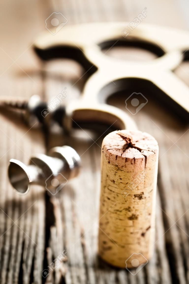 wine cork and corkscrew on wooden table