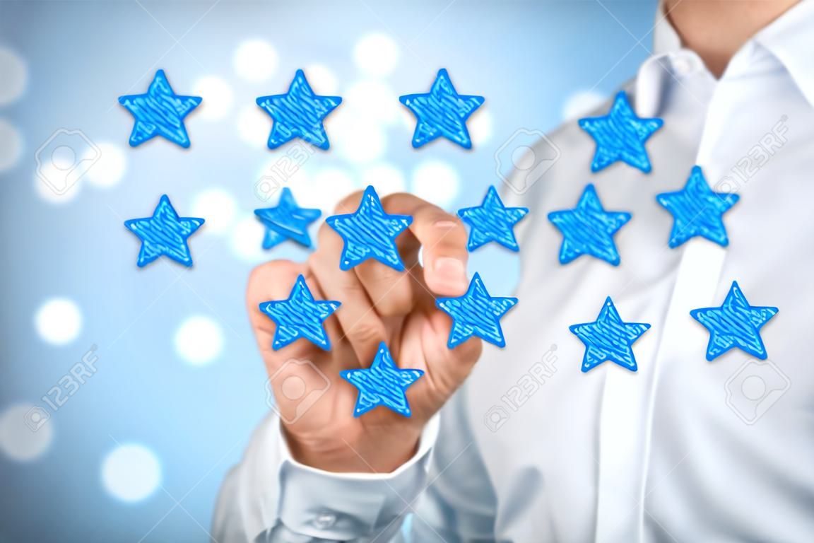 Beoordelen, verhogen rating of rangschikking, evaluatie en classificatie concept. Businessman tekenen vijf gele ster om de rating van zijn bedrijf te verhogen. Bokeh op de achtergrond.