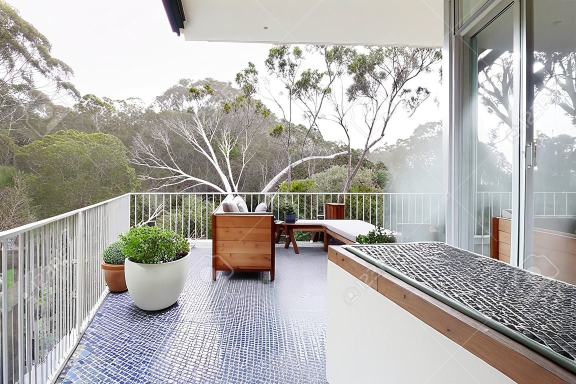Vista de la copa de los árboles de gran terraza de baldosas de mosaico en la casa de lujo de Australia
