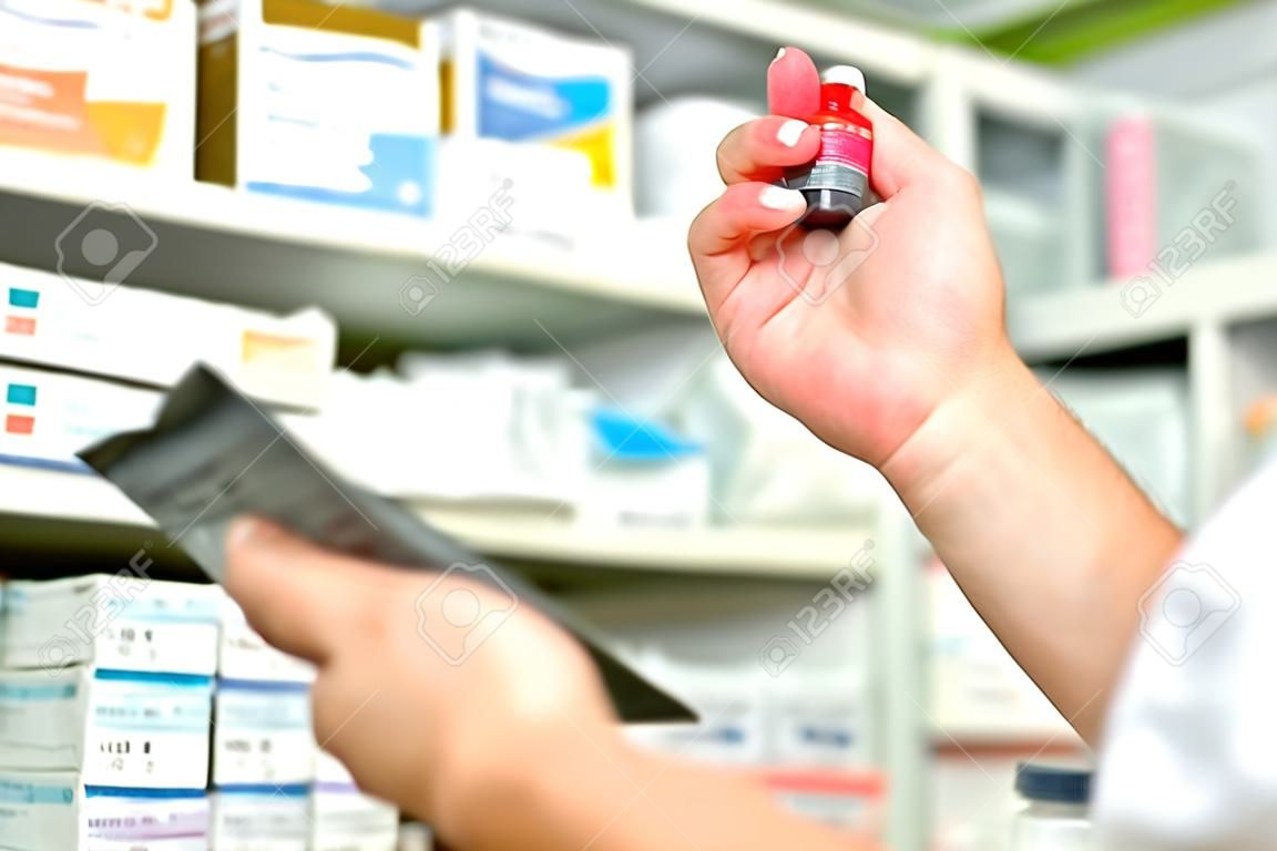 Farmacêutico segurando garrafa de medicamento e gráfico de prescrição para o preenchimento de receita em farmácia farmácia