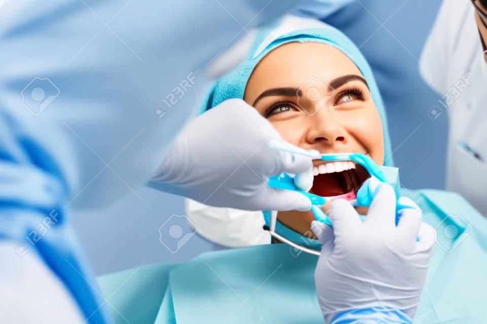 el médico realiza el procedimiento para limpiar los dientes