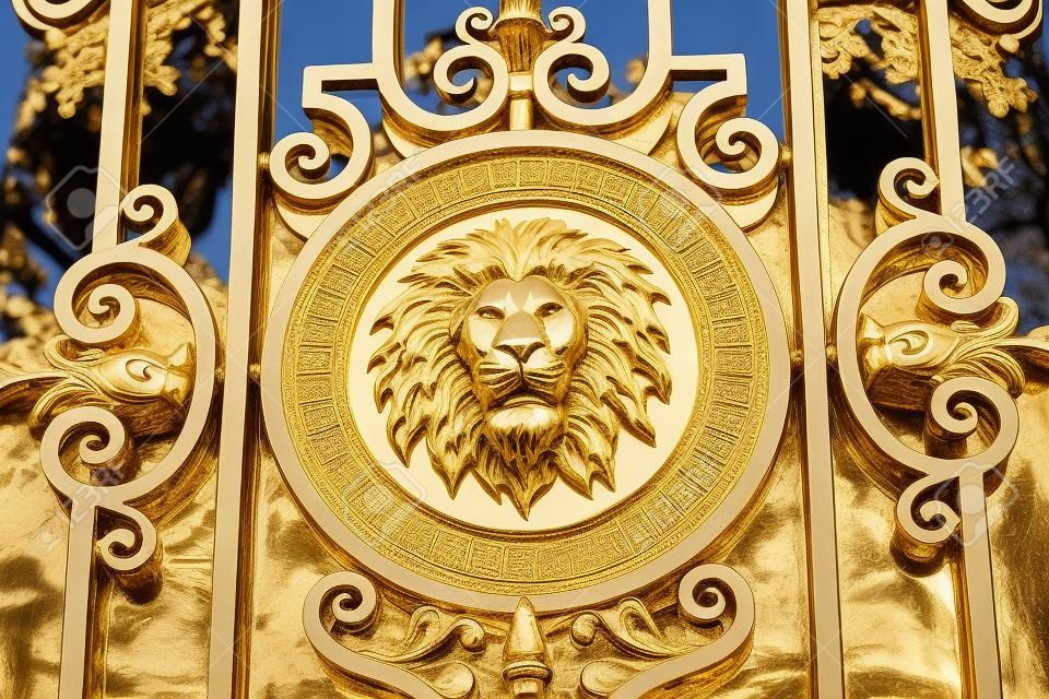 Um medalhão de leão dourado situado em um portão de ferro forjado ornamentado em Paris, França.