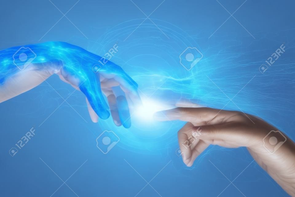 AI mano se extiende hacia una mano humana como una chispa de comprensión de la tecnología se extiende a través de la humanidad. Concepto de la inteligencia artificial con copia del espacio. Imagen carne azul.