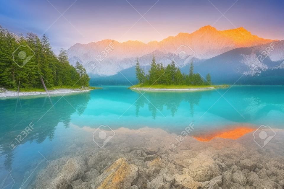 Impressive summer sunrise on Eibsee lake with Zugspitze mountain range. Sunny outdoor scene in German Alps, Bavaria, Germany, Europe. Beauty of nature concept background.