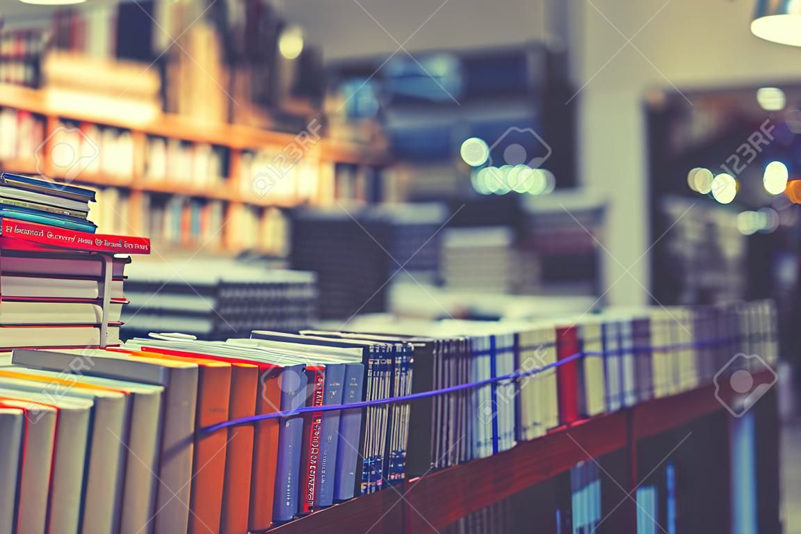 muchos libros nuevos en tapa dura. imagen de la gente de Abstract Blur en la librería en el centro comercial para uso de fondo. tonificado