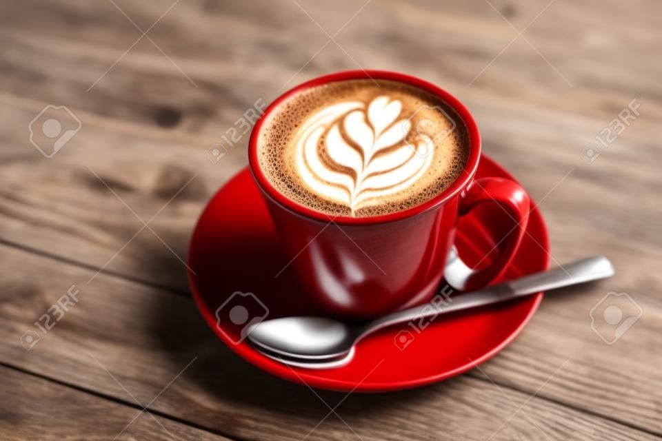 Tasse heißen Kaffee mit Milchkunst auf der Oberfläche auf dem Holztisch
