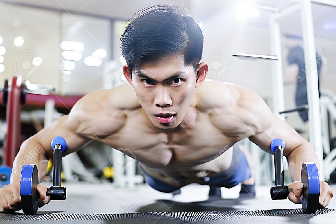 Atractivos hombres jóvenes asiáticos guapos entrenan con barra de empuje en el gimnasio enfocados en la sensación muscular tan fuerte y poderosa, concepto de culturista
