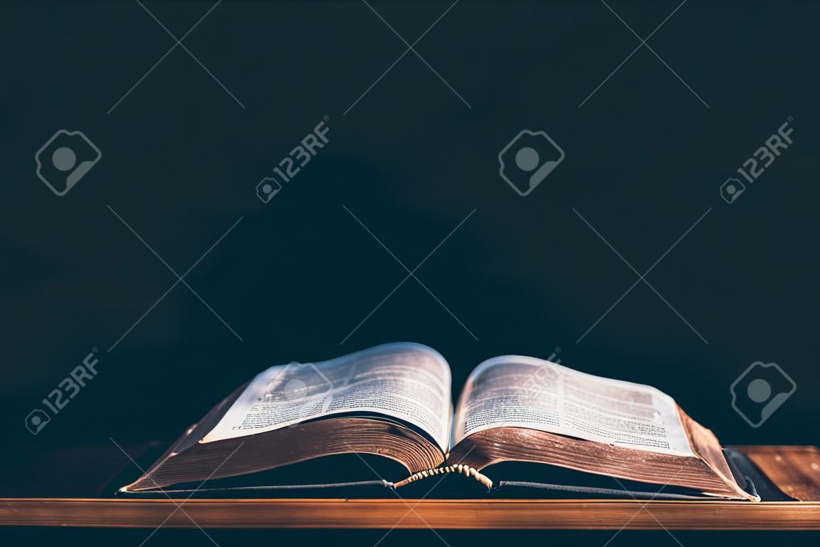 Open bible on black background