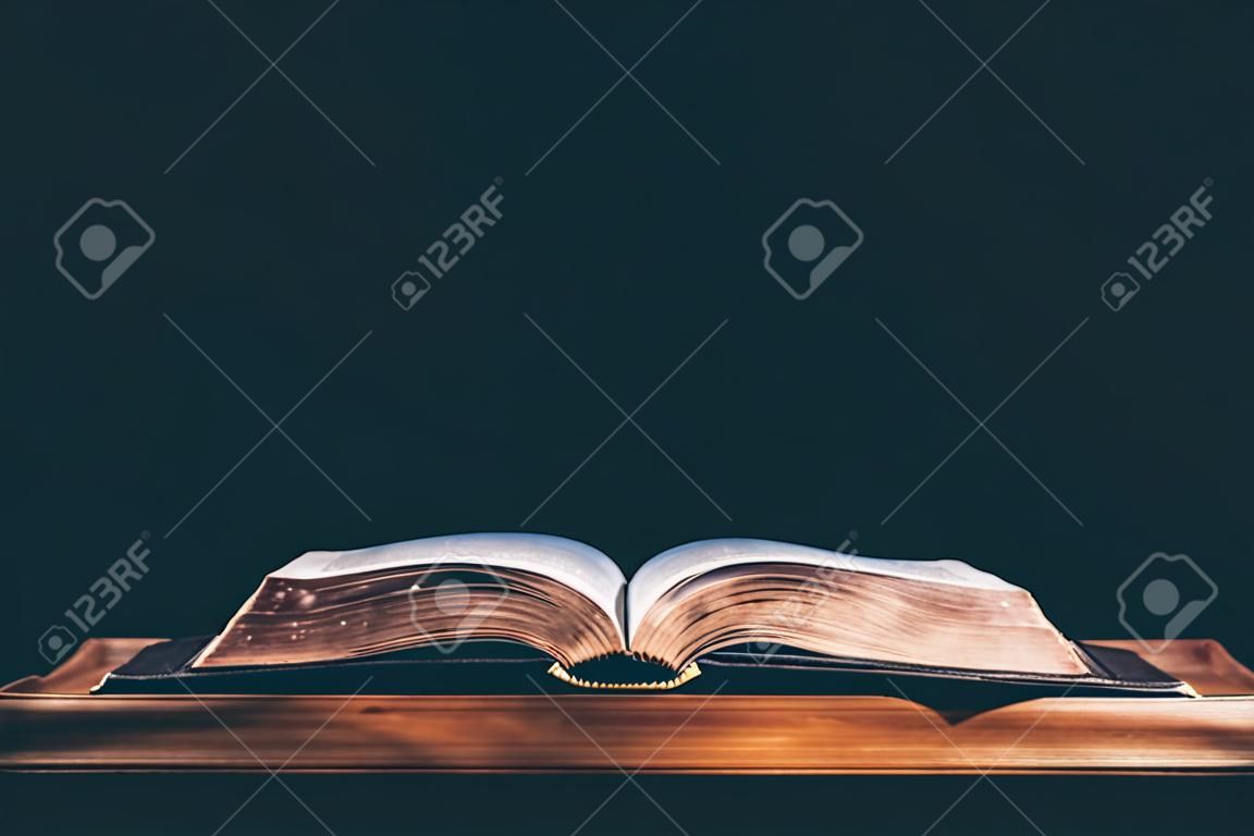 Open bible on black background